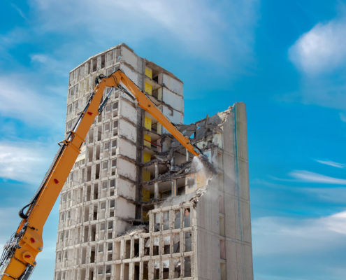 Building being demolished with rubble then to be deposited in a skip bin.
