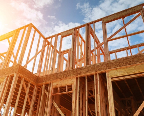 New residential construction home framing against a blue sky
