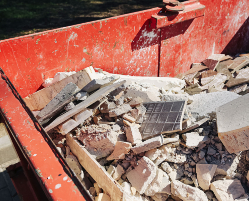 Red construction dumpster with rubble